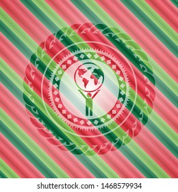man lifting world icon inside christmas colors style emblem.