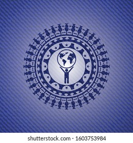 man lifting world icon inside badge with denim background