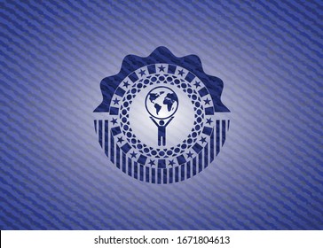 man lifting world icon inside jean or denim emblem or badge background