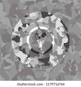 man lifting world icon on grey camouflaged texture