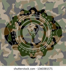 man lifting world icon on camouflage pattern