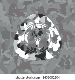 man lifting world icon on grey camouflage texture