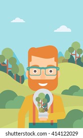 Man with lightbulb and trees inside.
