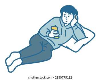 A man lying down and looking at a smartphone