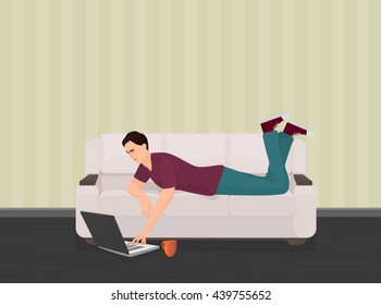 Man lying on the couch sofa and using a laptop lying on the floor