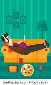 Man lying on sofa with many gadgets.