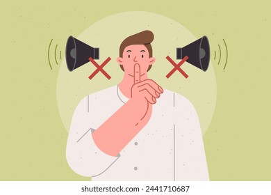 Man makes tss gesture urging to switch phone to airplane mode and speak in whisper, standing near crossed out megaphones. Guy recommends keeping quiet so as not to disturb people around him.