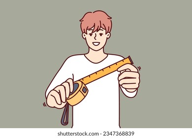 Man with measuring tape offers to find out exact size room to start repairing or building. Guy with measuring tape or ruler demonstrates dimension tool for accurate selection of furniture in apartment