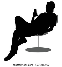 A man with a mobile phone sits in an armchair and is resting