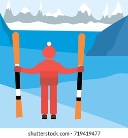 A man with mountain skis in the background of a winter mountain landscape