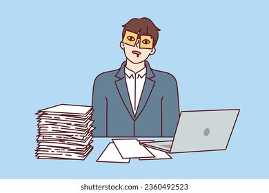 Man office worker is sleeping at workplace with sticky stickers on eyes and sitting at table with papers and computer. Guy is tired of paperwork and bureaucratic procedures sleeping