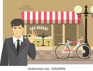 The man on the background of a small town bakery shows excellent hand sign