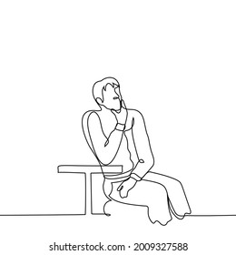 man on the summer veranda of a cafe at the moment of inspiration, reflection. man sits at a small table but looks in a different direction, his hand rests on the table and palm strokes his chin - one 
