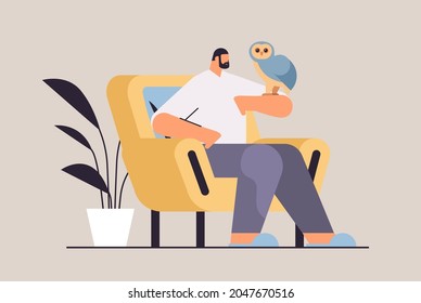 man with owl guy taking care of pet animal bird