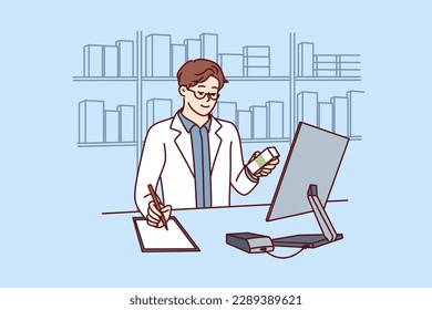 Man pharmacist in white medical coat stands behind counter in pharmacy and prescribes prescription drugs to patients. Pharmacy employee makes notes in notebook choosing antibiotics or vitamins 