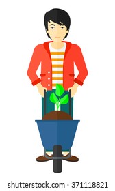 Hombre con planta y carretilla.