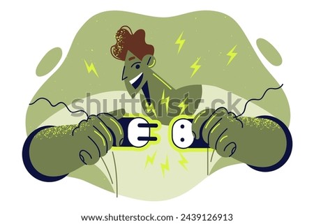 Man plugs plug into socket and rejoices at appearance current thanks to green energy from eco-friendly power stations. Guy risks getting electric shock due to careless handling energy appliances