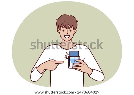 Man pointing finger at perfume bottle recommending to buy cologne or antiperspirant with cool scent. Happy guy employee of perfume shop holding sample of deodorant that protects against bad smell
