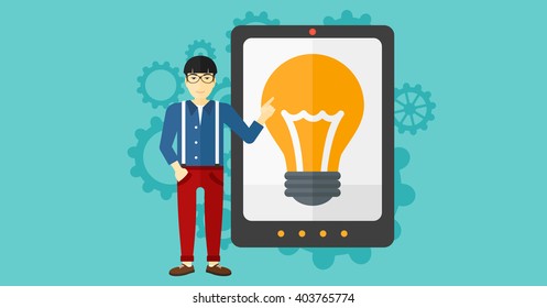 Man pointing at tablet computer with light bulb on screen.