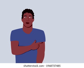 man points with his hand to the right, black guy shows the direction with his finger, young african american man in t-shirt stands isolated on light background