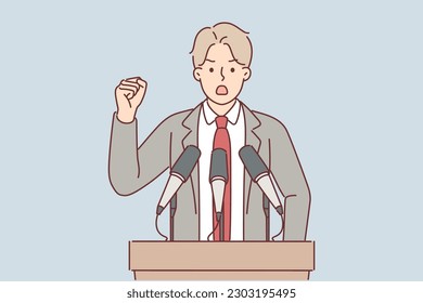 Man politician stands behind podium with microphone and gesticulates giving election promises to electorate. Orator politician in formal suit gives press conference and waves hand menacingly