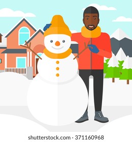 Man posing near snowman.