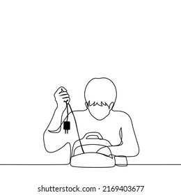 man pulls out a charger from a backpack - one line drawing vector.  concept of carrying a charger for a smartphone, a mess in a briefcase
