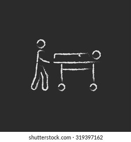 Man pushing stretcher hand drawn in chalk on a blackboard vector white icon isolated on a black background.