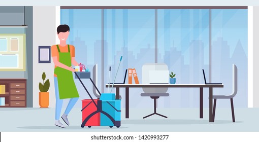 man pushing trolley cart male cleaner janitor in uniform cleaning service concept modern co-working center office interior flat full length horizontal