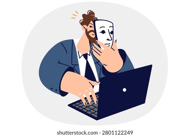 Man puts on mask, using internet and introduces himself as another person, sitting at table with laptop. Business guy with mask in hand, for concept of office hypocrisy and identity substitution