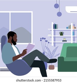 Mann, der ein Buch liest, das im Zimmer sitzt
