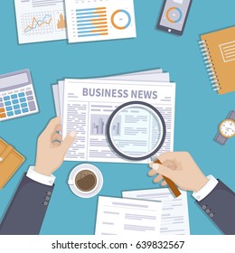 Man reading latest business news. Magnifying glass over newspaper. Businessman holding in his hand journal on the desktop. Coffee break in the workplace. Documents, notebook, coffee. View from above.