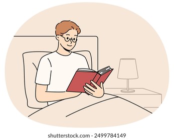 Man reads book before bedtime, sitting in bed at night and enjoying plot of fantasy novel. Smart young guy student preparing for exam in bed studying textbook with educational information