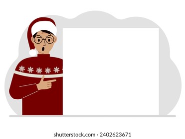 A man in a red sweater near a large white sheet. Advertising, invitation, discount for Christmas or New Year.