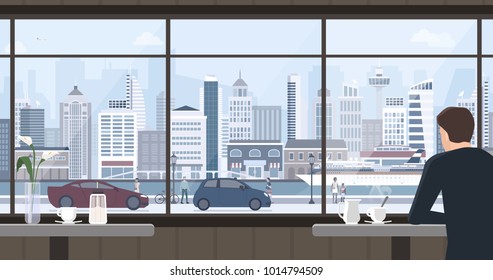 Man relaxing at the cafe, he is having a coffee and staring at the window, city view on the background