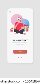 man in santa claus hat sitting near gift present boxes merry christmas happy new year winter holidays celebration concept smartphone screen online mobile app full length sketch vertical vector