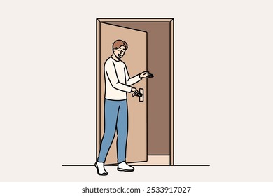 Man says welcome standing near door and shows inviting gesture when friends come to visit. Guy demonstrating welcome sign with palm, showing friendly and hospitable character traits