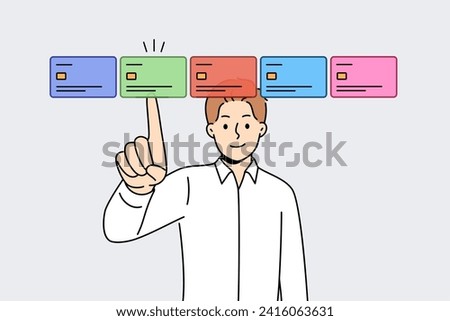 Man selects credit card on virtual screen, wanting to make cashless payments through web banking application. Obtaining new credit card using modern technologies to ensure secure online shopping