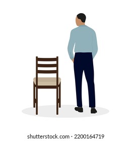 A man in a shirt stands near a chair on a white background