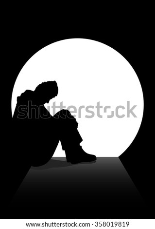 A man in silhouette sitting on the ground in a dark tunnel.