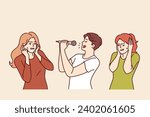 Man sings karaoke poorly due to lack of hearing or voice and forces women to cover ears. Singer holds microphone enjoying visit to karaoke club and annoys people experiencing discomfort.