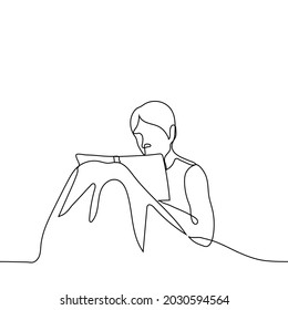 man sits in bed and reads a book with his knees under the covers - one line drawing. bedtime reading, keeping a diary  or morning pages concept 