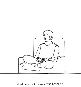 man sits in a chair with his legs raised and holds a joystick (game console) in his hands - one line drawing. gamer playing games sitting in a chair in turkish 