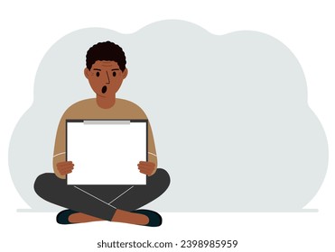 A man sits crossing his legs and holds a clipboard with a white read sheet for the text in his hands.