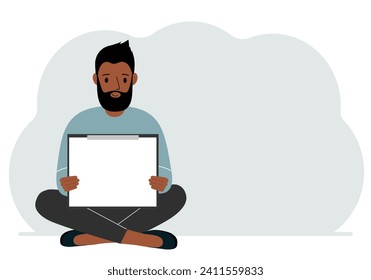 A man sits crossing his legs and holds a clipboard with a white read sheet for the text in his hands.