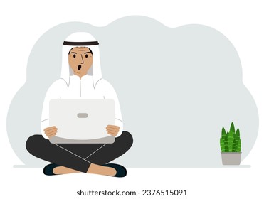 A man sits cross-legged in his hands holding a laptop. The concept of work, education, reading, watching videos.