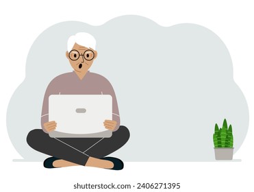 A man sits cross-legged in his hands holding a laptop. The concept of work, education, reading, watching videos.