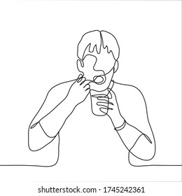 A man sits with his mouth open and holds a spoon in his mouth and a glass. One continuous line art of a man eating ice cream / yogurt. Can be used for animation.