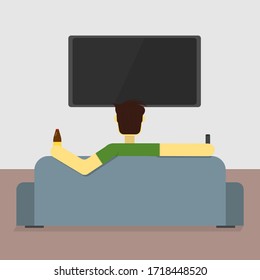 A man sits on a couch and watches TV
