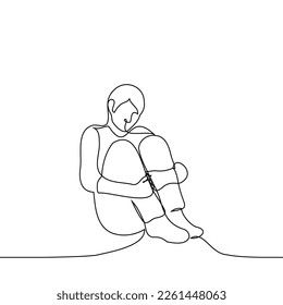 man sits on the floor hugging his legs - one line drawing vector. concept loneliness, abandonment, isolation